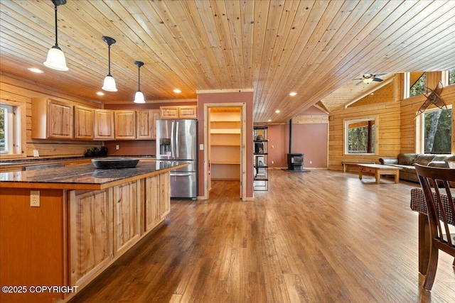 kitchen with a wood stove, wooden ceiling, stainless steel fridge with ice dispenser, wood-type flooring, and open floor plan