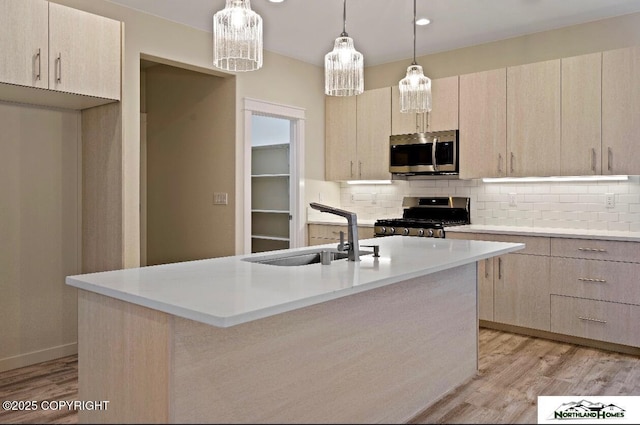 1205 N Williwaw Way, Wasilla, AK 99654 - kitchen featuring appliances with stainless steel finishes, a sink, light countertops, light wood-type flooring, and tasteful backsplash