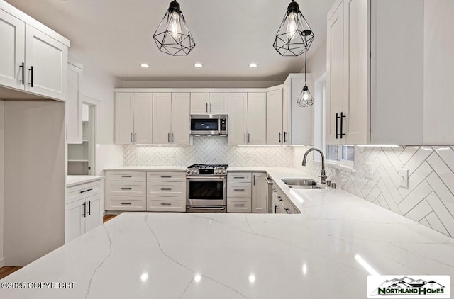 1205 N Williwaw Way, Wasilla, AK 99654 - kitchen with white cabinets, light stone countertops, appliances with stainless steel finishes, a sink, and decorative backsplash
