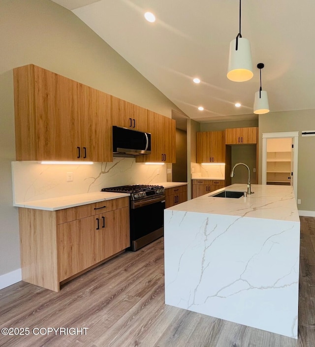 1205 N Williwaw Way, Wasilla, AK 99654 - kitchen with stainless steel appliances, light wood-style floors, vaulted ceiling, light stone counters, and decorative light fixtures