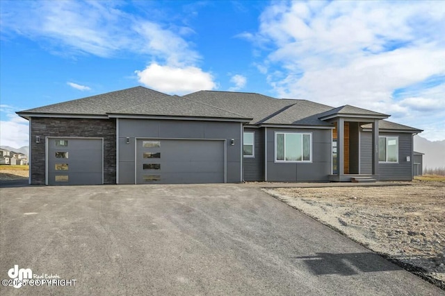 2600 S Sanctuary Dr, Wasilla, AK 99654 - prairie-style home with a garage, asphalt driveway, roof with shingles, and stone siding