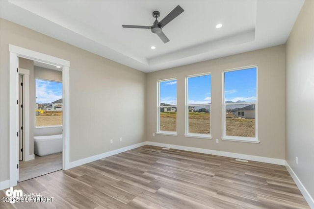 2600 S Sanctuary Dr, Wasilla, AK 99654 - unfurnished bedroom featuring light wood-style flooring, a tray ceiling, recessed lighting, and ceiling fan