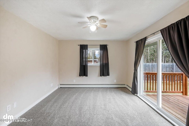 carpeted spare room featuring baseboards, ceiling fan, a baseboard heating unit, and a healthy amount of sunlight