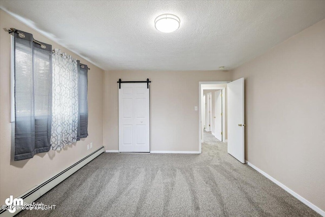 unfurnished bedroom featuring carpet flooring, a barn door, a textured ceiling, baseboards, and a baseboard radiator