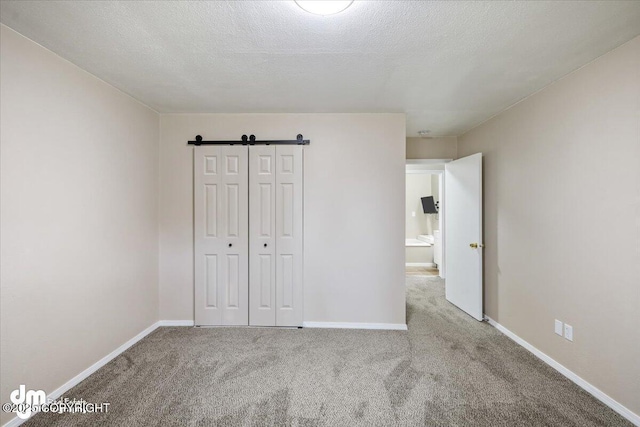 unfurnished bedroom featuring baseboards, carpet, a closet, and a textured ceiling
