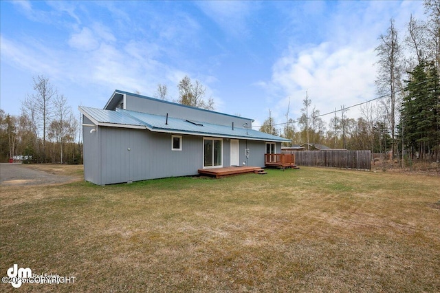 rear view of house with metal roof, a yard, and a deck