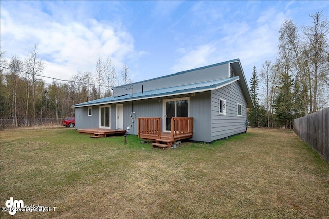 rear view of house featuring a fenced backyard, a yard, a deck, and metal roof
