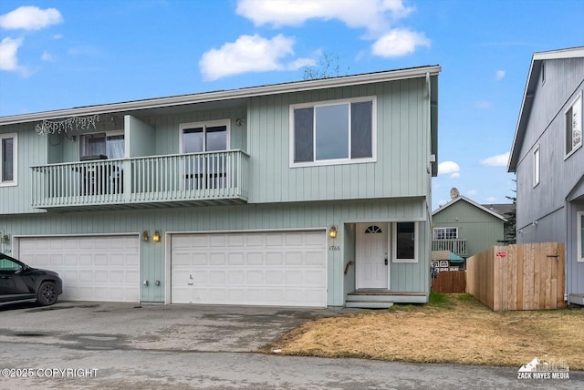view of front of home featuring an attached garage, aphalt driveway, and fence