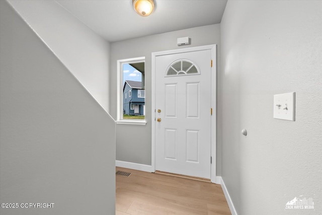 foyer featuring visible vents, baseboards, and light wood-type flooring
