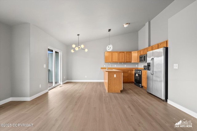 kitchen featuring baseboards, a notable chandelier, appliances with stainless steel finishes, and a sink