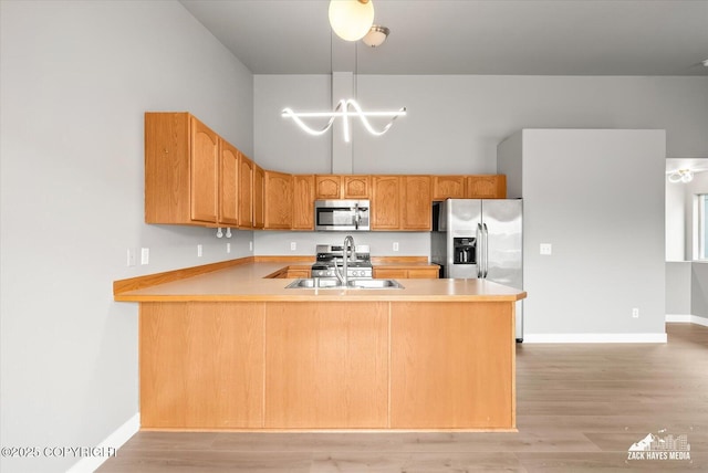 kitchen with light countertops, a sink, a notable chandelier, and stainless steel appliances