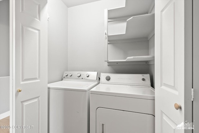 clothes washing area featuring separate washer and dryer and laundry area