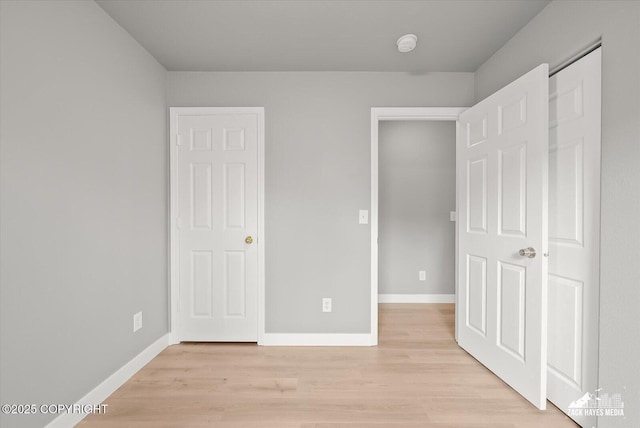 unfurnished bedroom with baseboards and light wood finished floors