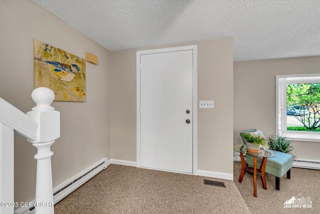 3294 Montpelier Ct # 12-E, Anchorage, AK 99503 - entryway with a textured ceiling, baseboard heating, carpet flooring, and baseboards