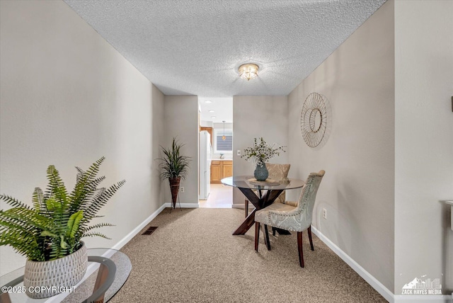 3294 Montpelier Ct # 12-E, Anchorage, AK 99503 - dining space featuring carpet, baseboards, and a textured ceiling