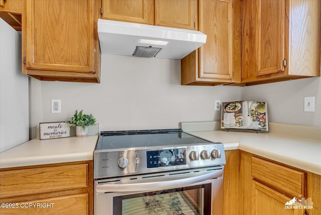 3294 Montpelier Ct # 12-E, Anchorage, AK 99503 - kitchen featuring stainless steel electric stove, under cabinet range hood, and light countertops