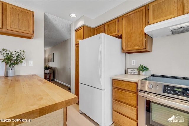 3294 Montpelier Ct # 12-E, Anchorage, AK 99503 - kitchen featuring electric stove, freestanding refrigerator, under cabinet range hood, recessed lighting, and brown cabinets