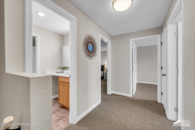 3294 Montpelier Ct # 12-E, Anchorage, AK 99503 - hallway featuring light carpet, baseboards, and a textured ceiling