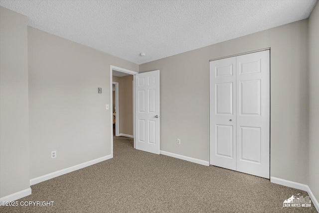 3294 Montpelier Ct # 12-E, Anchorage, AK 99503 - unfurnished bedroom with carpet flooring, baseboards, a closet, and a textured ceiling