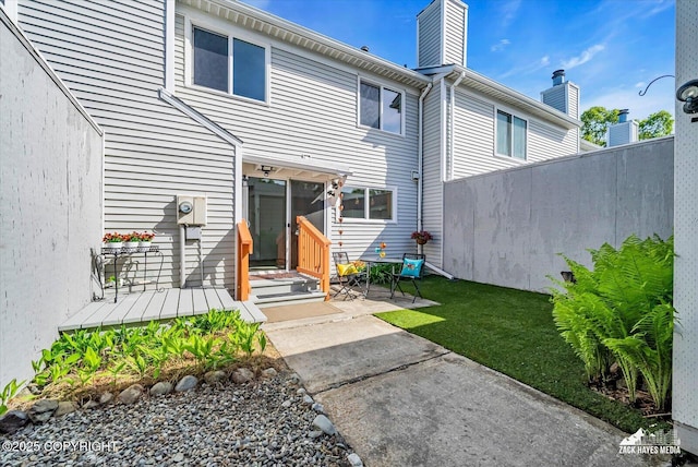 3294 Montpelier Ct # 12-E, Anchorage, AK 99503 - back of house with a patio, a chimney, and a lawn