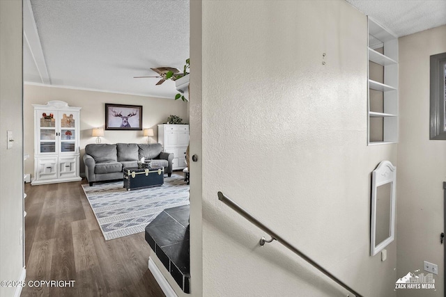living area featuring a textured ceiling, ceiling fan, and wood finished floors
