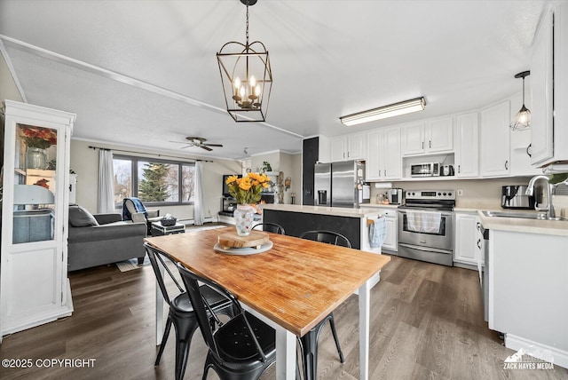 dining area with dark wood-style flooring and ceiling fan with notable chandelier