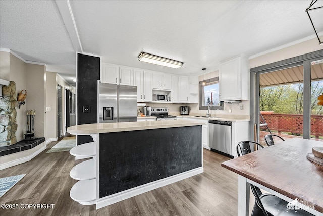 kitchen with white cabinets, open shelves, appliances with stainless steel finishes, and light countertops