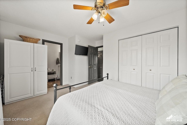 bedroom featuring a ceiling fan, baseboards, light colored carpet, and a closet