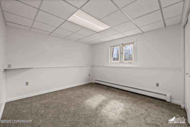 spare room with carpet floors, a baseboard radiator, and a drop ceiling