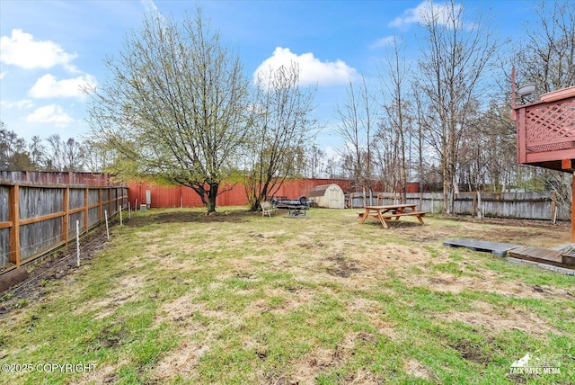 view of yard with a fenced backyard, an outbuilding, and a shed