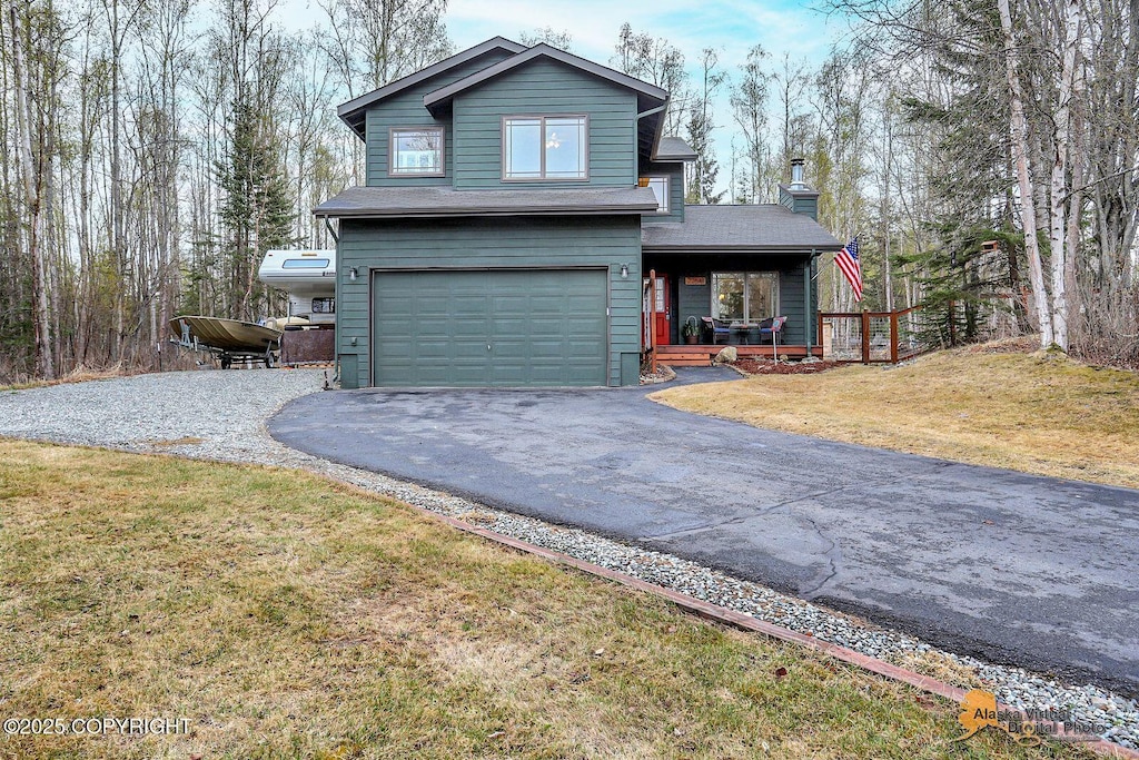 view of front of home with a garage, a porch, a front lawn, and aphalt driveway
