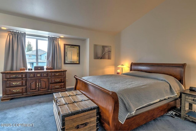 bedroom with dark colored carpet and baseboards
