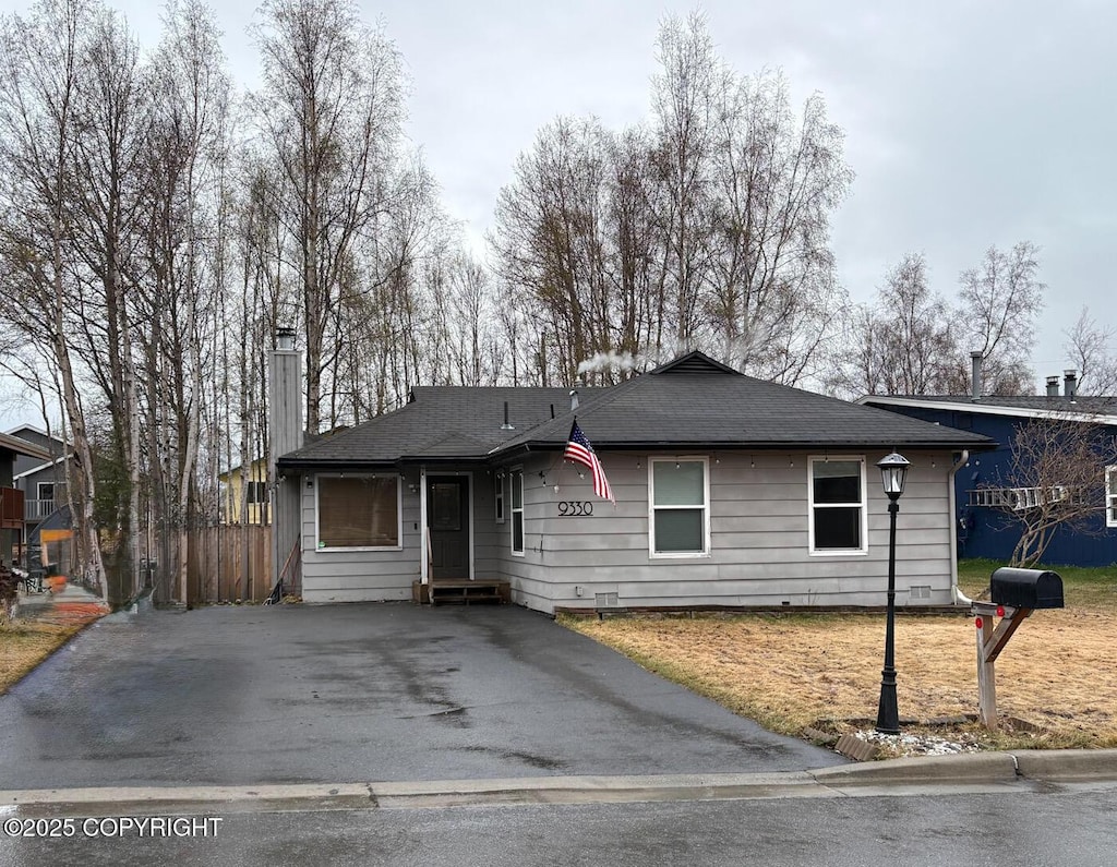 single story home with fence, a chimney, and aphalt driveway