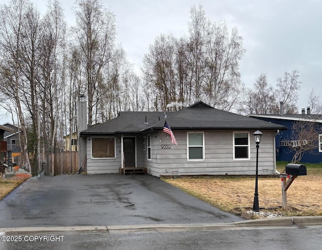 single story home with fence, a chimney, and aphalt driveway