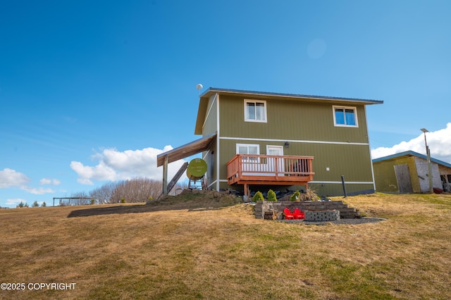 rear view of house featuring a wooden deck and a lawn
