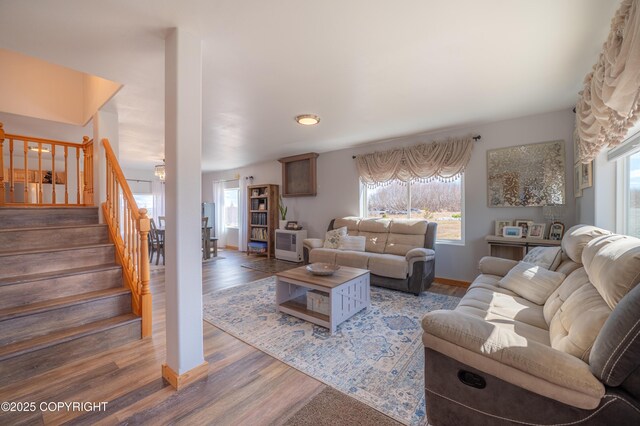 living room with wood finished floors, stairway, and baseboards