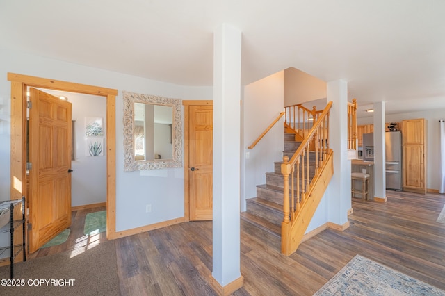 stairway featuring baseboards and wood finished floors