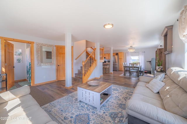 living area featuring wood finished floors, stairs, and baseboards
