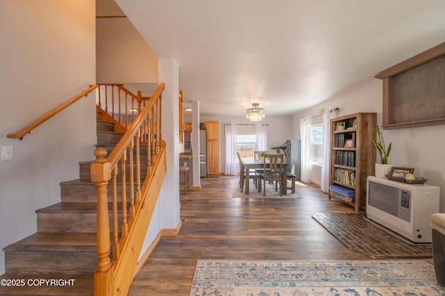 dining area featuring stairs, wood finished floors, heating unit, and baseboards