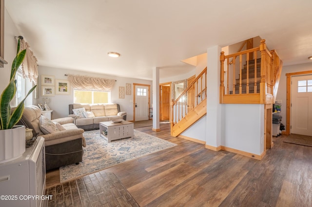 living room featuring wood finished floors, stairway, and baseboards
