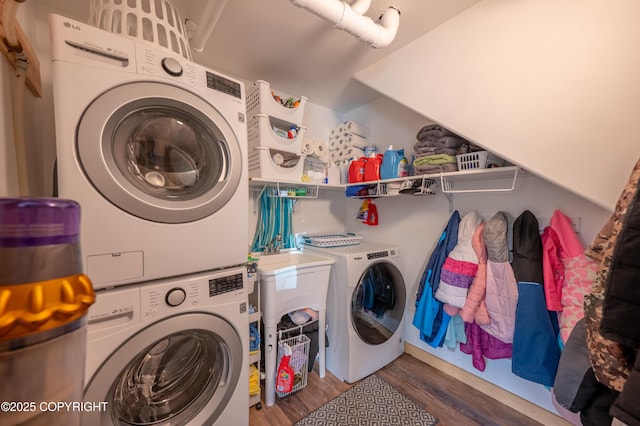 laundry area featuring stacked washing machine and dryer and wood finished floors