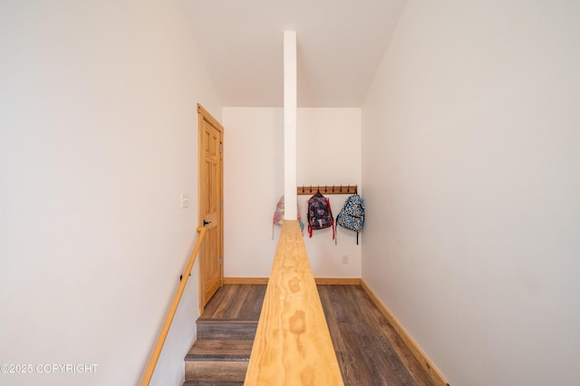 corridor with dark wood finished floors and baseboards