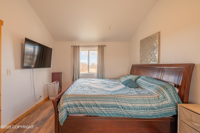 bedroom featuring lofted ceiling and wood finished floors