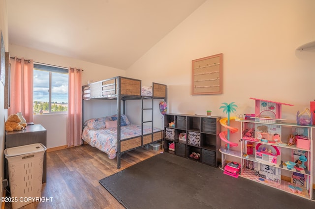 bedroom featuring lofted ceiling, wood finished floors, and baseboards