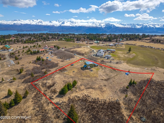aerial view of property and surrounding area with a mountain backdrop and property boundaries highlighted