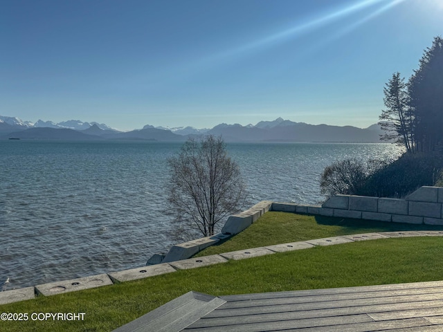 property view of water with a mountain view and fence