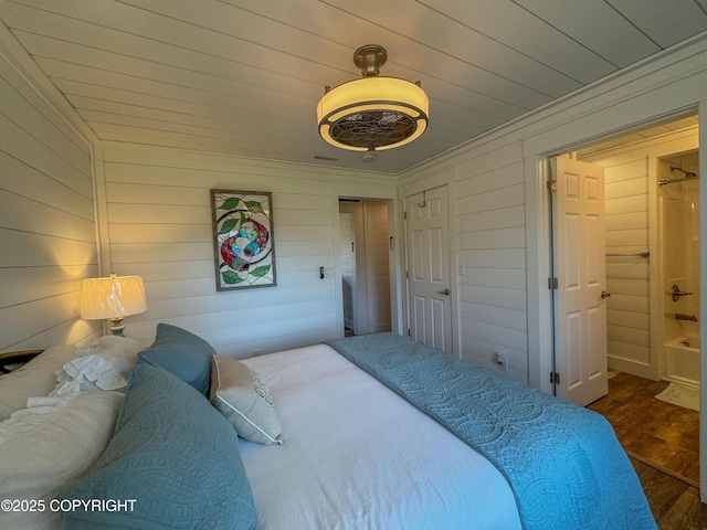 bedroom with crown molding, dark wood-style floors, and wooden walls