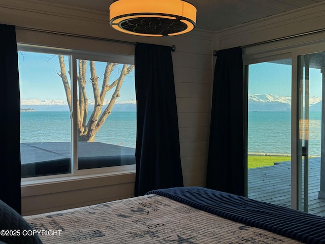 bedroom with a water view and access to exterior