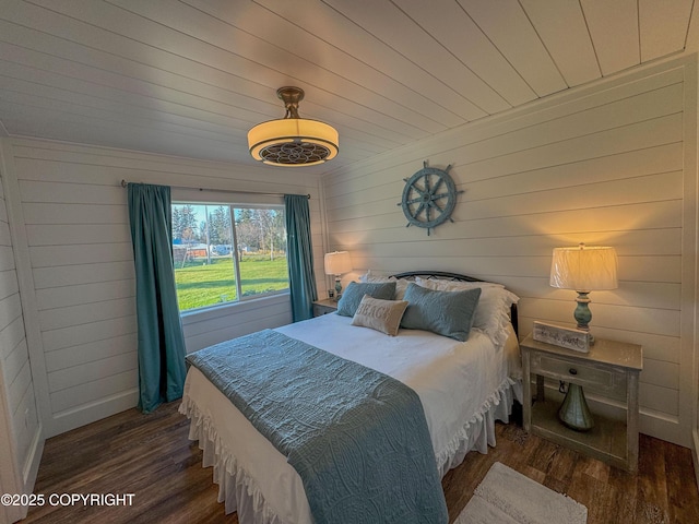 bedroom with wooden walls, wooden ceiling, and wood finished floors