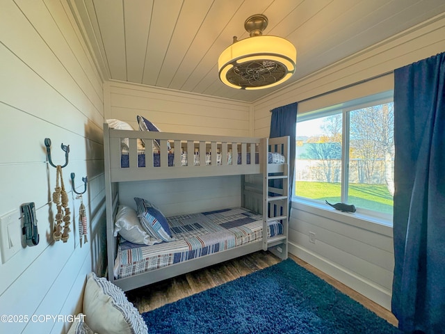 bedroom featuring wood walls and wood finished floors